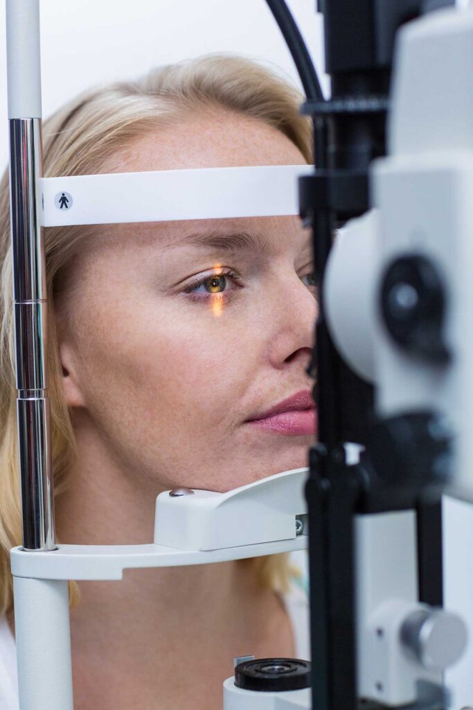 Woman with laser projecting into her eye to observe